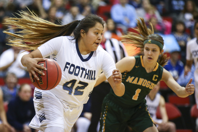 Foothill’s Trinity Betoney (42) drives the ball against Bishop Manogue guard Katie Tur ...