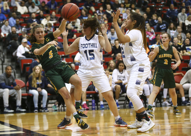 Bishop Manogue guard Malia Holt (5) passes the ball as Foothill’s Bri Rosales (15) and ...