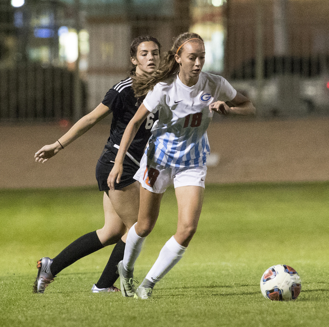 Taylor Cox (18) from Bishop Gorman High School, battles for the ball against Holly Lindholm ...