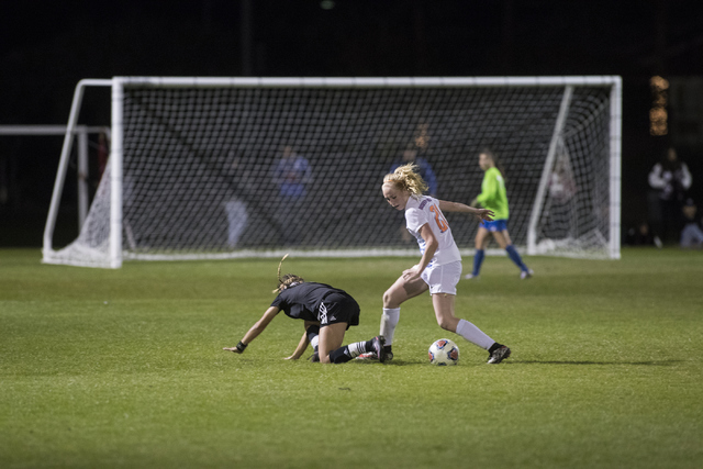 Kevyn Hillegas (21) from Bishop Gorman High School and Madison Hernandez (1) go for the ball ...