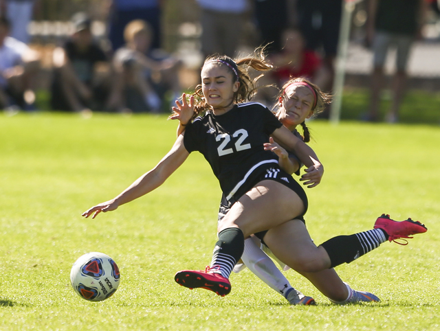 Palo Verde’s Sloan Nelson (22) kicks the ball while colliding with an unidentified Arb ...