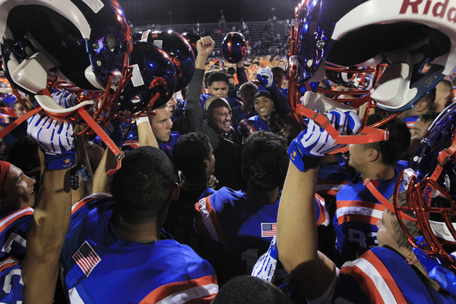 Bishop Gorman coach Tony Sanchez and his players celebrate defeating St. John Bosco, 34-31 o ...