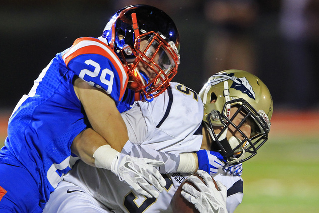 Bishop Gorman safety Bryce Garcia stops St. John Bosco running back Sean McGrew during their ...