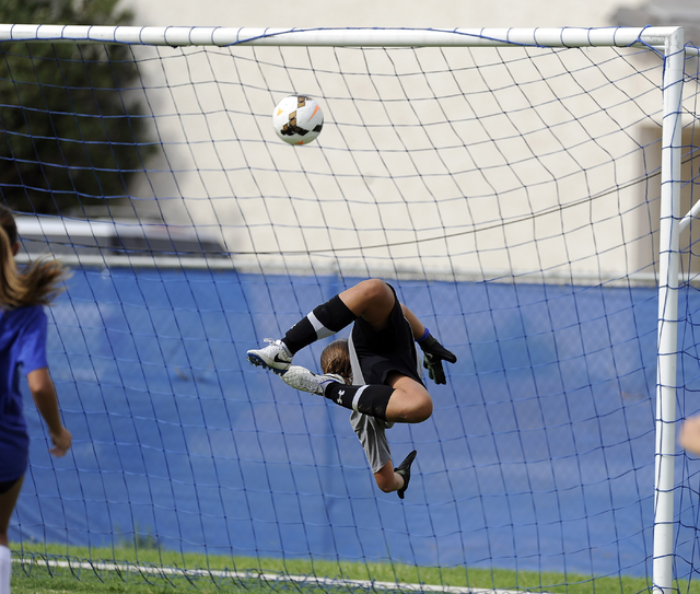 Green Valley girls soccer freshman goalkeeper Ryan Sabol tips a shot while diving backwards ...