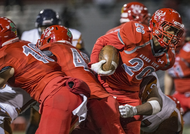 Arbor View’s Jaquari Hannie (20) breaks through the line past Legacy defenders during ...