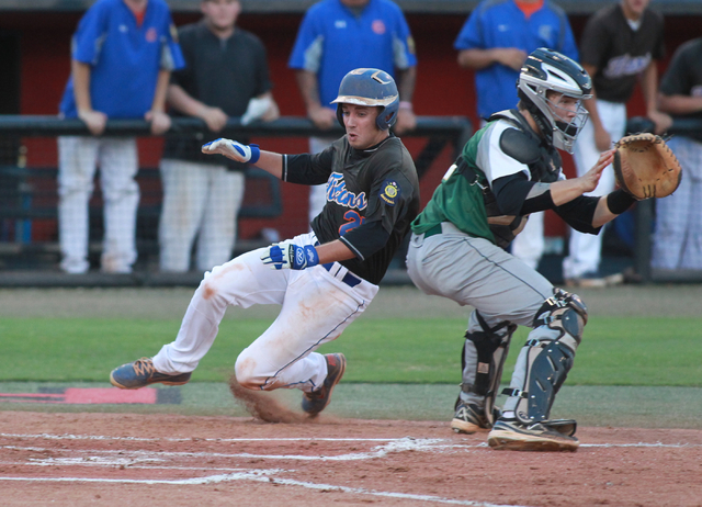 Bishop Gorman’s Grant Robbins (27) slides into home past Rancho catcher Zach Barnhart ...