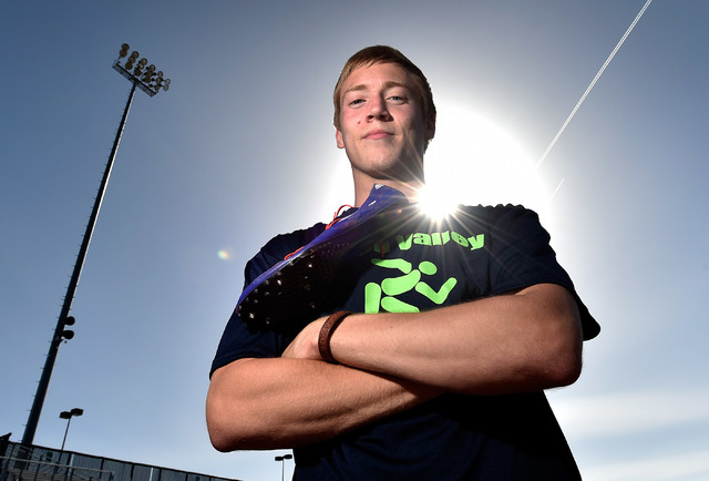 Ian Mack stands with his running spikes over his shoulder trackside at Green Valley High Sch ...