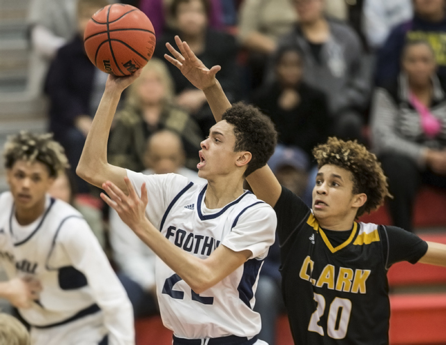 Foothill’s Jace Roquemore (22) slices to the rim past Clark’s Adam Forbes (20) ...