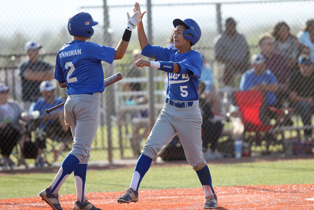 Green Valley’s Eric Samson (5) celebrates after scoring a run with Jarod Penniman (2) ...