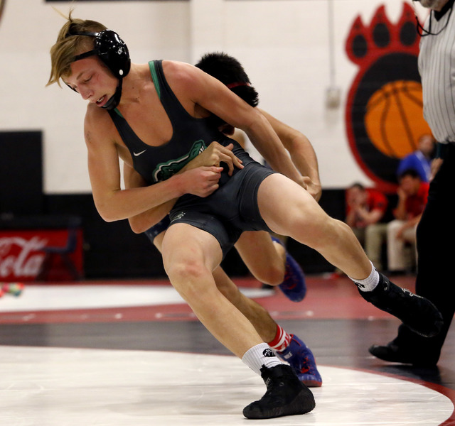 Green Valley’s Tyler Dockery, green singlet, attempts to escape from Liberty’s J ...