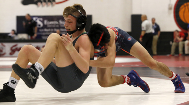 Green Valley’s Tyler Dockery, green singlet, attempts to escape from Liberty’s J ...