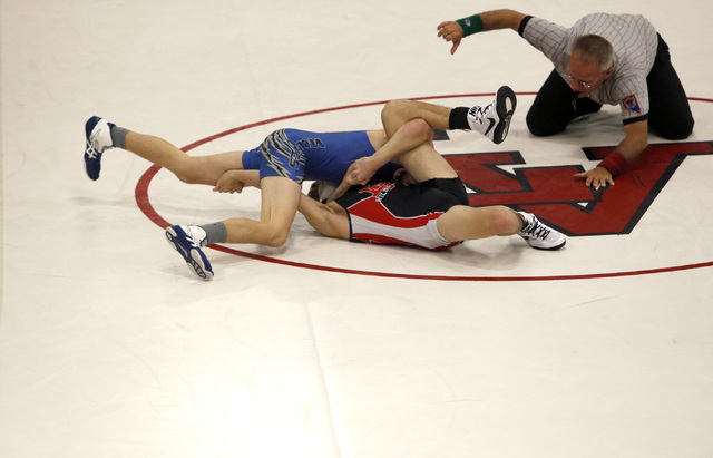 Basic’s Dane Dennett, blue singlet, attempts to pin Las Vegas’s Trace Everett du ...