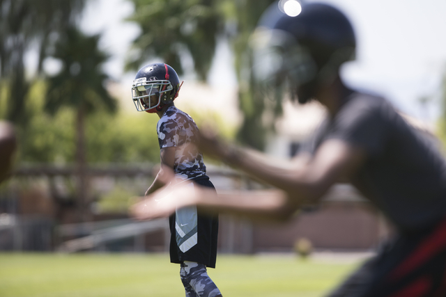 Terrence Brooks, left, 16, looks to his twin brother Tyrell for a pass during a team footbal ...