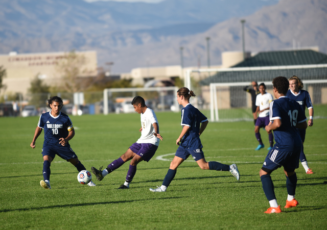 Durango’s Marcos Delgado (18) kicks the ball against Centennial defenders during their ...