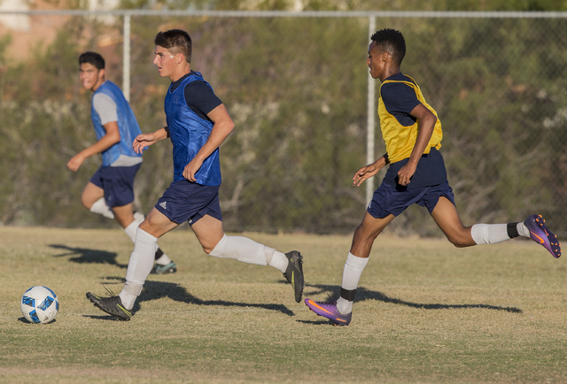 Spring Valley soccer player David Van Hoose, center, sprints past a defenders during practic ...