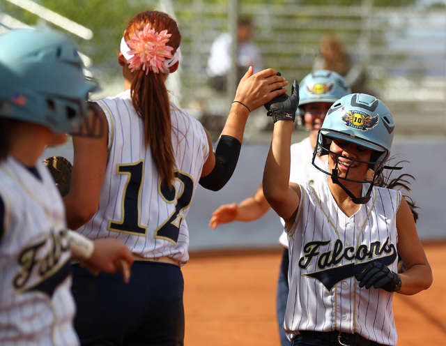 Foothill’s Vanessa Parrales high fives teammate Sarah Maddox (12) after scoring a run ...