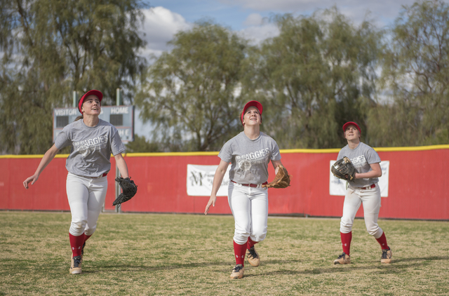 Triplets, from left, Brittany, Breanne and Bryce Henriksen, 16, go after a fly ball during a ...