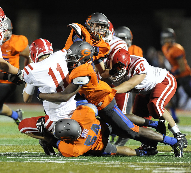 Brophy Prep quarterback Cade Knox (11) is tackled by Bishop Gorman linebacker Ikem Okeke, ri ...