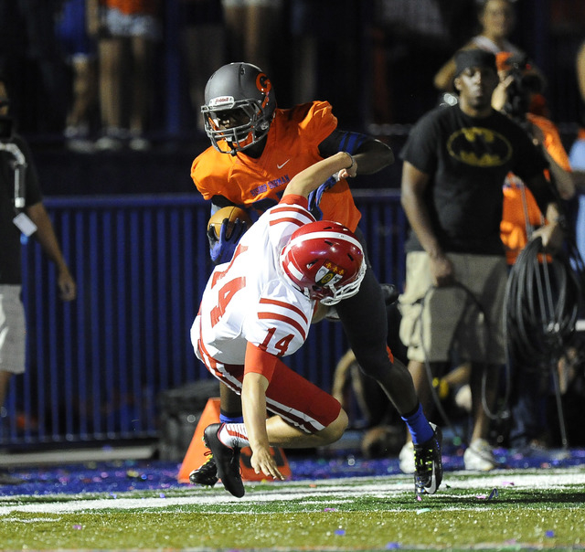 Bishop Gorman’s Tyjon Lindsey runs over Brophy Prep punter Jack Katzman (14) while ret ...