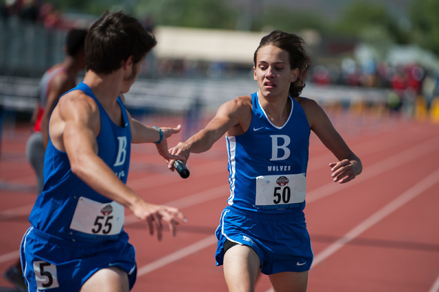 Basic’s Seth Blackwell, left, hands off the baton to teammate Daniel Peveler while com ...