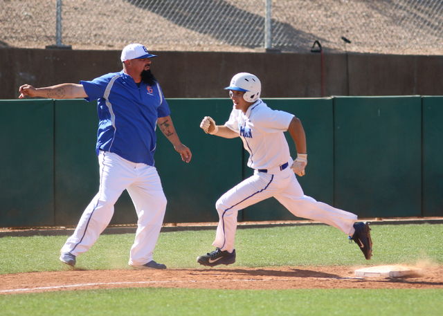 Bishop Gorman’s Grant Robbins, right, heads home as third base and head coach Gino DiM ...