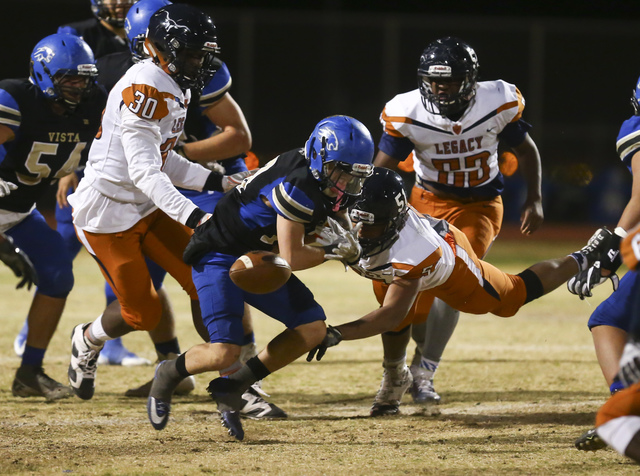 Sierra Vista Jaxson Zibert (13) fumbles the ball as Legacy’s Sergio Mendoza (51) dives ...