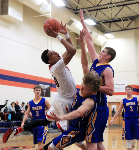 Las Vegas forward Tyler Bey crashes into Orem forward Noah Johnson and center Richard Harwar ...