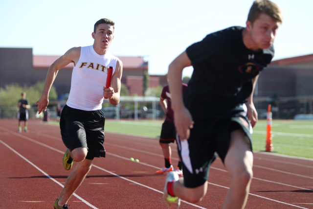 Faith Lutheran runner Mark Rubalcaba, 18, left, works on the baton pass with a teammate duri ...