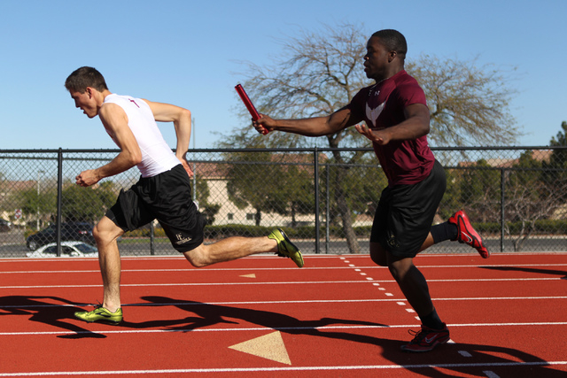 Faith Lutheran runner Mark Rubalcaba, 18, left, works on the baton pass with teammate Alfred ...