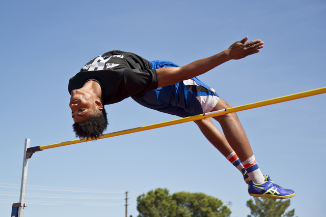 Basic High School high jumper Frank Harris clears the bar while demonstrating his high jump ...