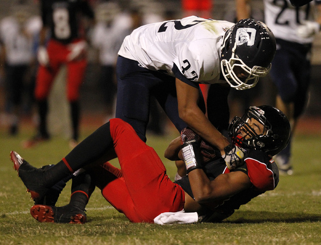 Centennial defender Samuel Liaga hits Las Vegas wide receiver Raul Perez on Saturday. (Justi ...