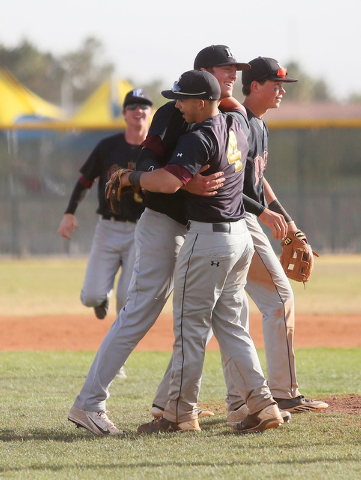 Faith Lutheran senior Brandon Johnson, center, receives a hug from shortstop Logan Etheringt ...