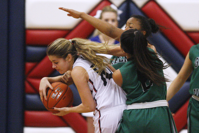 Coronado guard Payton Caci grabs a rebound away from Green Valley guards Yamilei Rodriguez a ...