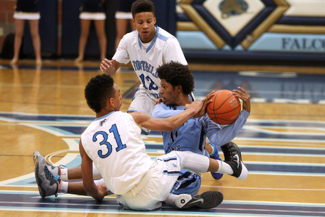 Canyon Springs guard Zaahid Muhammad keeps a loose ball away from Foothill guards Marvin Col ...