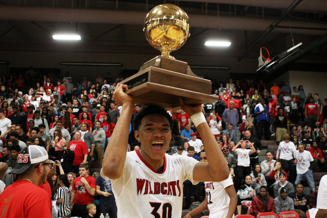 Las Vegas forward Tyler Bey holds the "V Game" trophy aloft after the Wildcats def ...