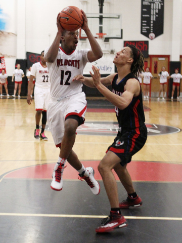 Las Vegas guard Devon Colley passes around Valley forward Taveon Jackson during their " ...