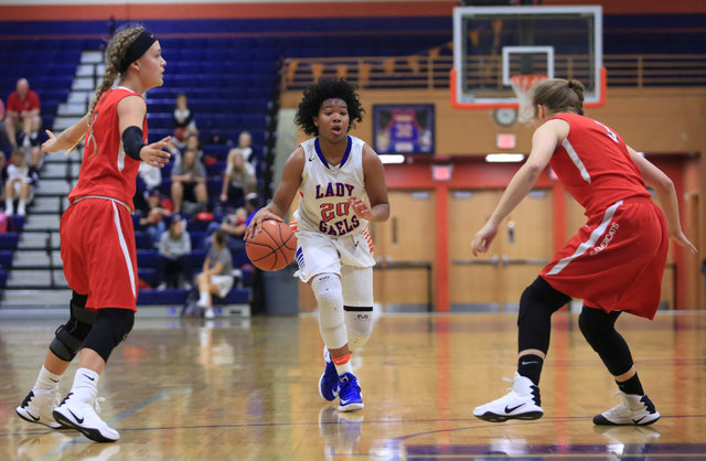 Bishop Gorman Senior Skylar Jackson (20) dribbles the ball between two defenders during the ...