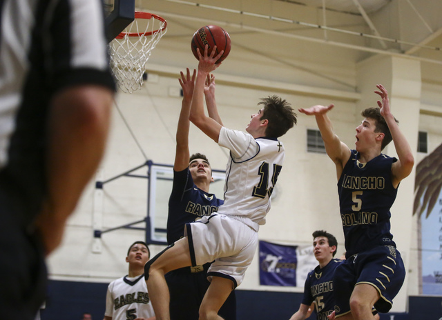 Lake Mead’s Shay Rutledge (15) gets past Rancho Solano defenders to score during a bas ...