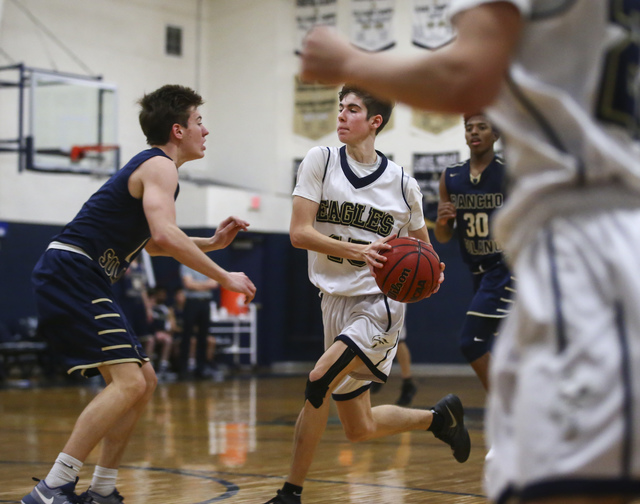 Lake Mead’s Shay Rutledge (15) looks to drive past Rancho Solano’s Caden Hoffman ...