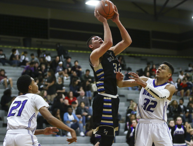 Sierra Vista guard Maka Ellis (32) shoots between Durango guard Anthony Hunter (21) and forw ...