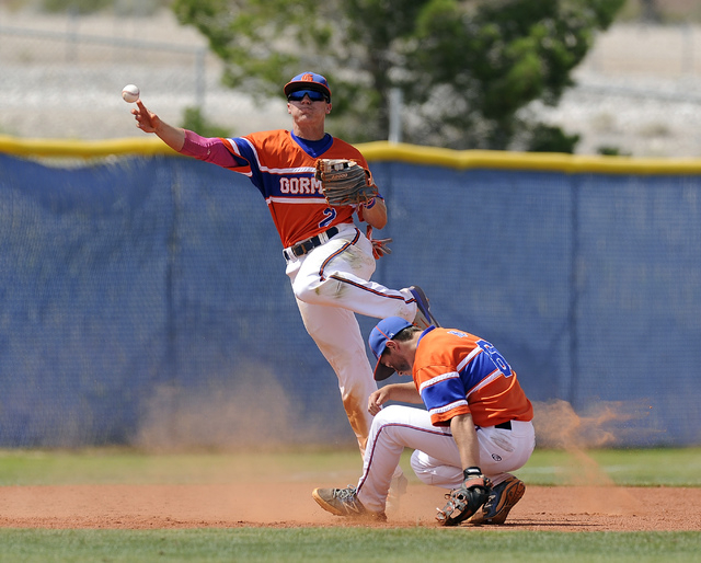 Bishop Gorman shortstop Cadyn Grenier makes an acrobatic throw over third baseman Beau Capan ...