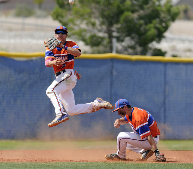 Bishop Gorman shortstop Cadyn Grenier makes an acrobatic throw over third baseman Beau Capan ...