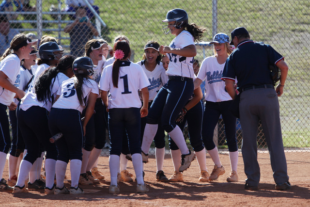 Centennial’s Brianna Benoit leaps into her teammates after a home run during their so ...