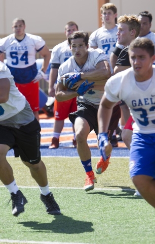 Bishop Gorman running back Baggio Ali Walsh, center, (7) runs a football during team practic ...