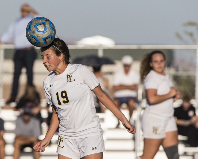 Faith Lutheran’s Nikki Amavisca (19) heads a ball out of danger during her team’ ...