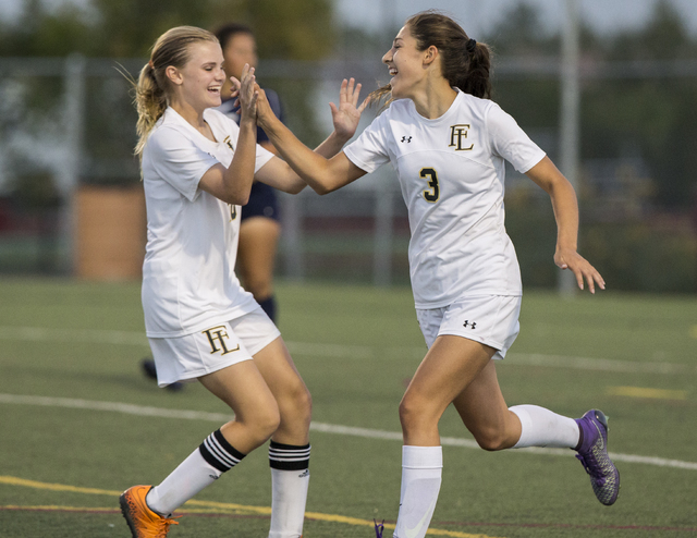 Faith Lutheran’s Isabella Gutierrez (3) celebrates with teammate Amelia McManus (20) ...