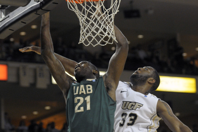 UAB center Beas Hamga, left, puts up a shot in front of Central Florida’s Keith Clanto ...