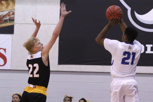 Bishop Gorman’s Christian Popoola (21) shoots over Clark’s Trey Woodbury (22) du ...