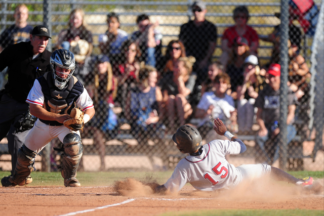 Liberty base runner Jayzen Ramirez slides home safely ahead of Coronado catcher Corben Bella ...