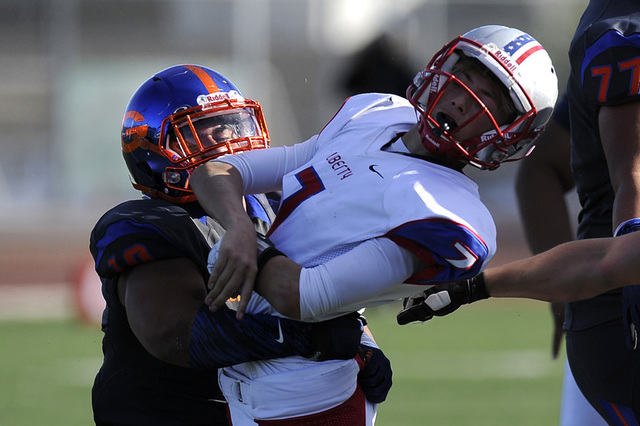 Bishop Gorman middle linebacker Nela Otukolo (10) wraps up Liberty quarterback Kenyon Oblad ...